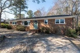 a small brick house with trees in front of it
