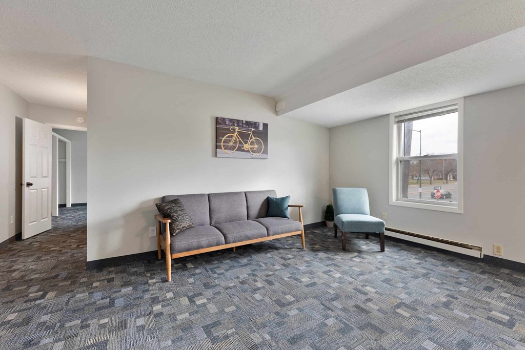 a living room with a couch and a chair and a window