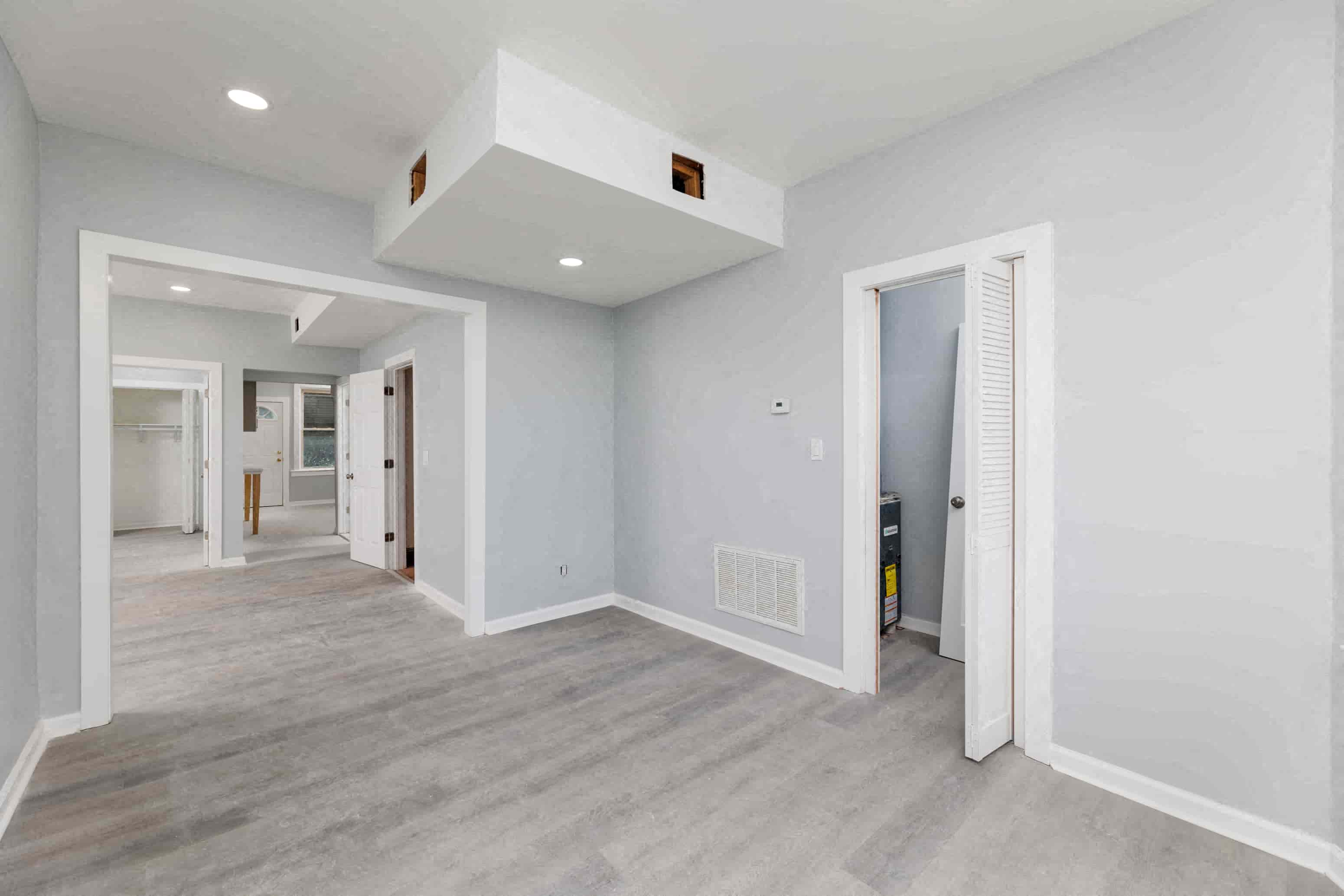 a renovated living room with white walls and wood floors