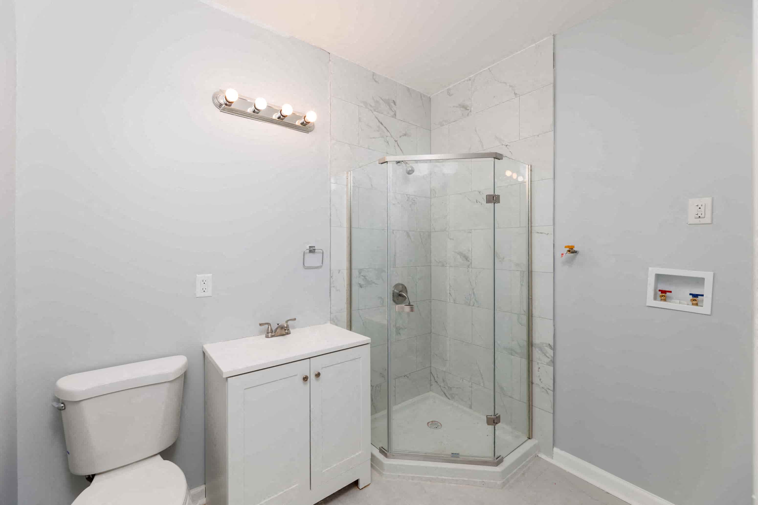 a bathroom with a shower and a toilet and a sink