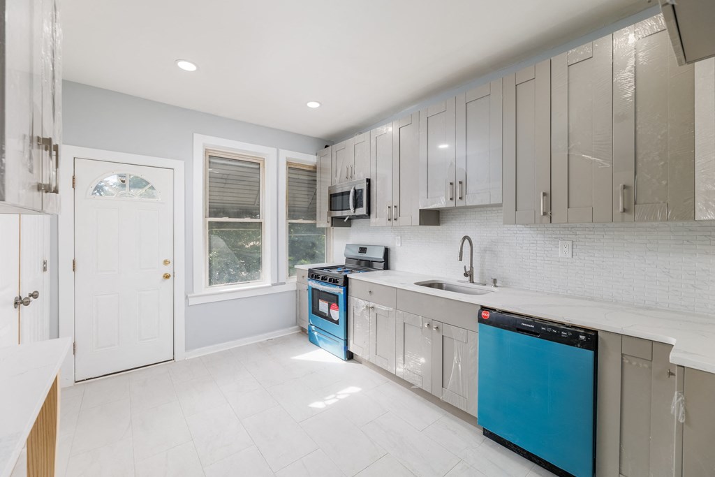 a white kitchen with blue appliances and white cabinets