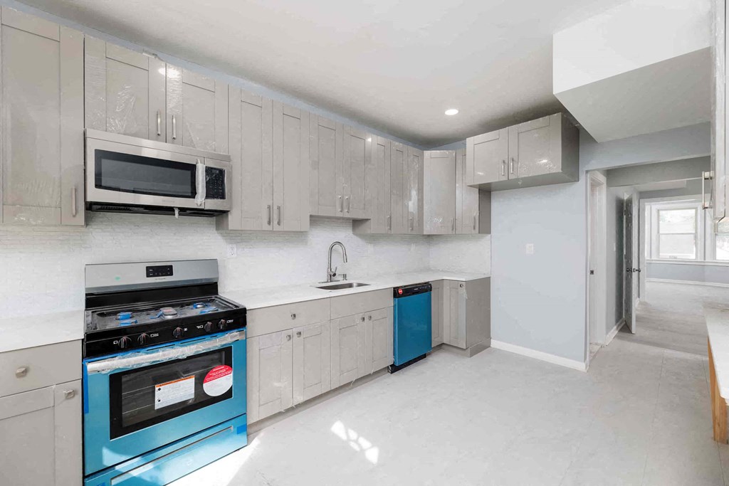 a white kitchen with blue appliances and white cabinets