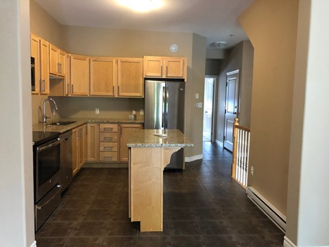 a kitchen with wooden cabinets and stainless steel appliances