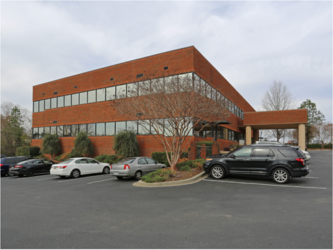 a large brick building with cars parked in a parking lot