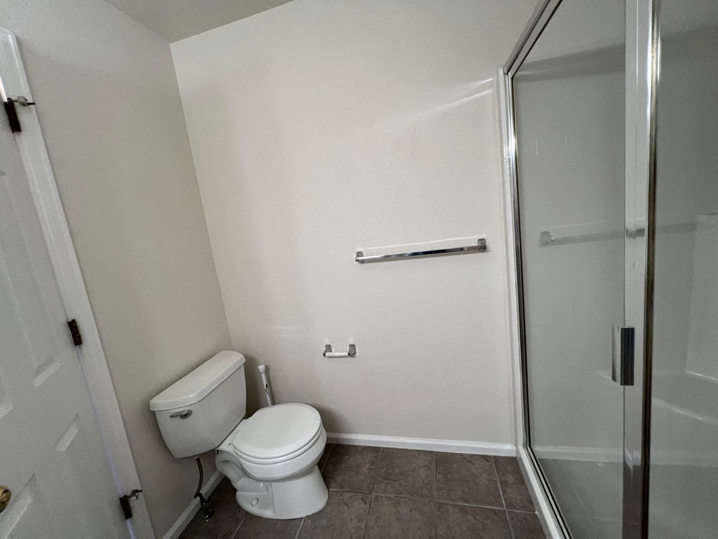 an empty bathroom with a toilet and a shower