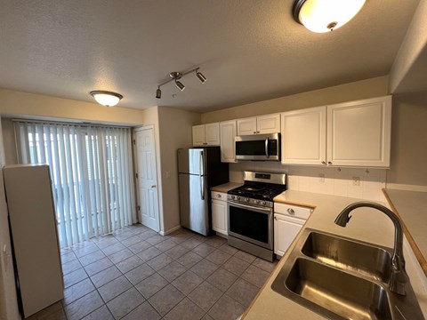 a kitchen with stainless steel appliances and white cabinets