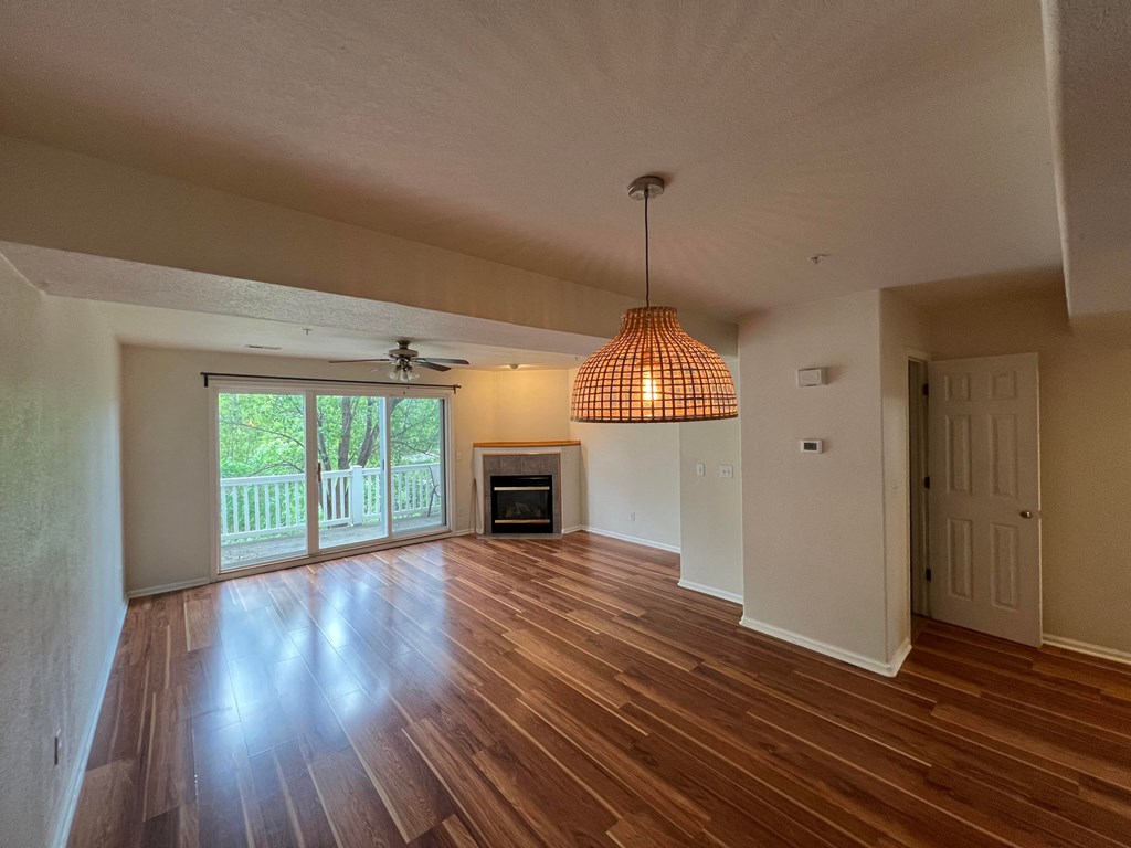 an empty living room with wood floors and a fireplace