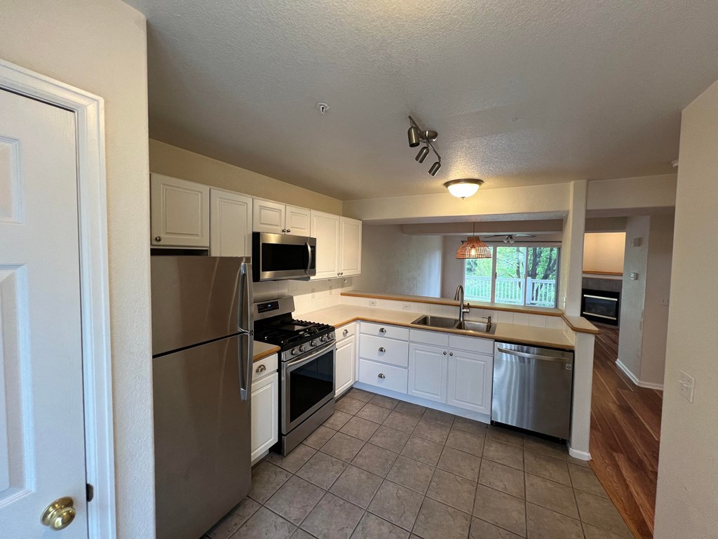a kitchen with stainless steel appliances and white cabinets