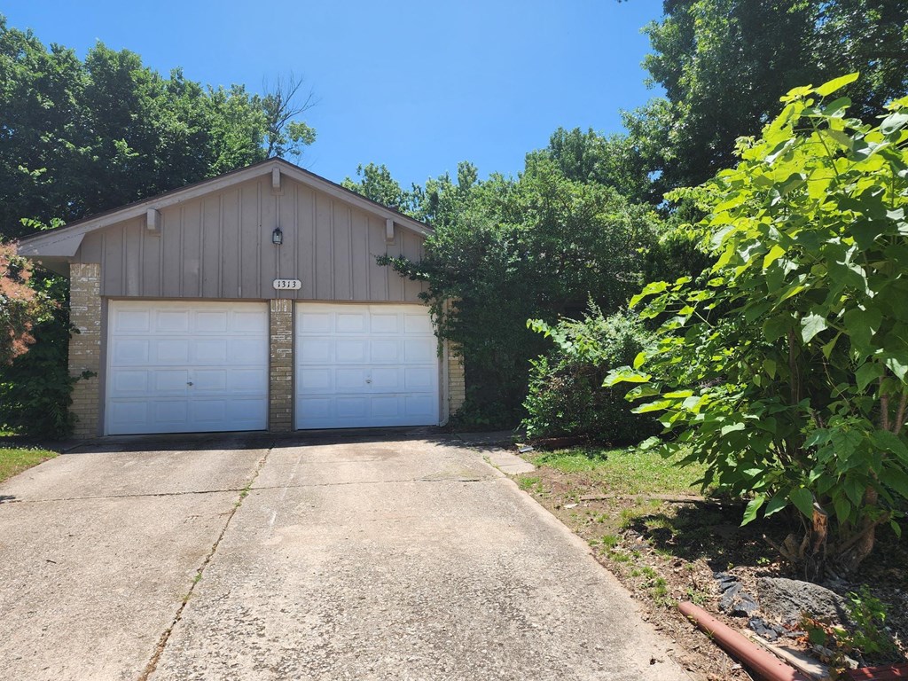 a garage with a white garage door on the side of a house