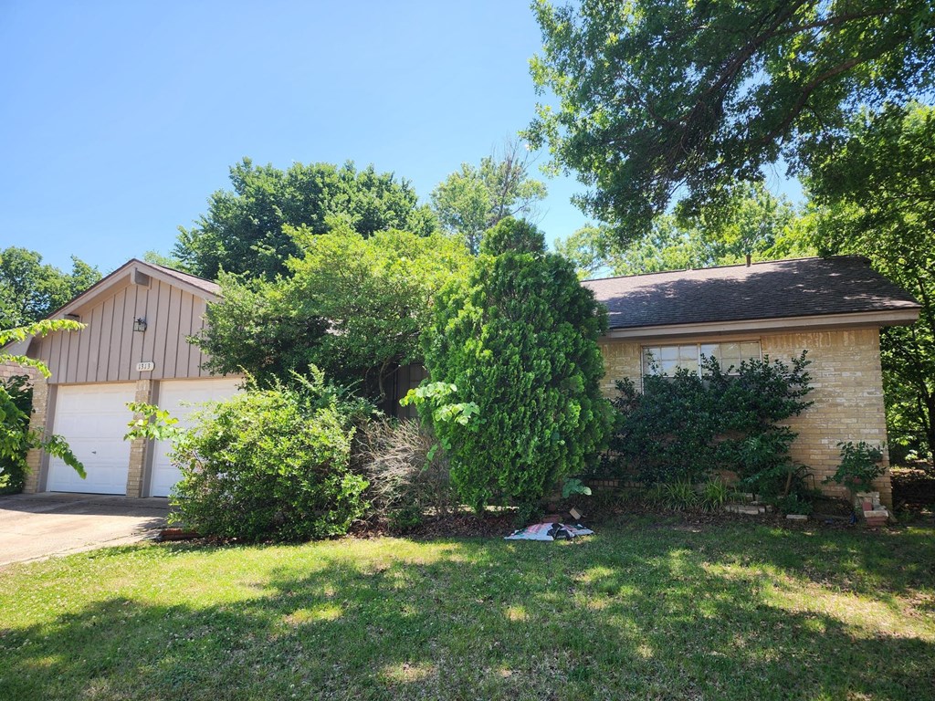a house with a garage and a tree in front of it