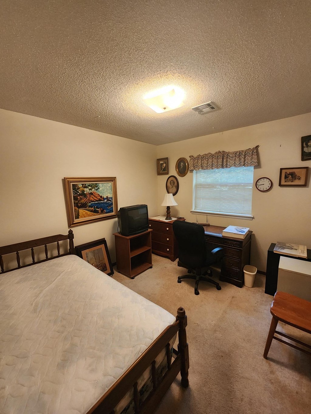 a bedroom with a bed and a desk and a window