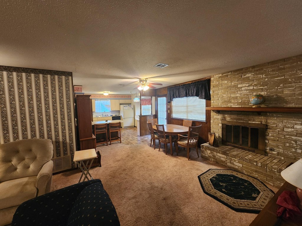 a living room with a fireplace and a dining room