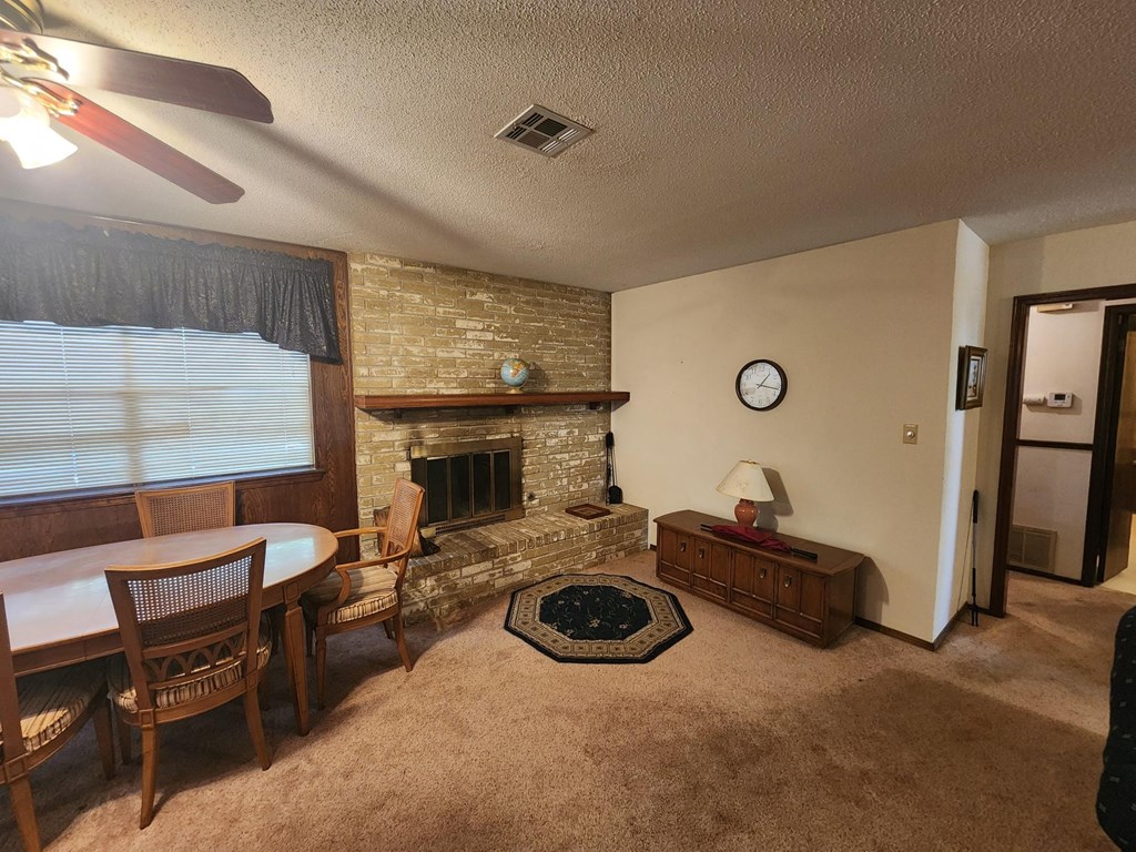 a living room with a fireplace and a table and chairs