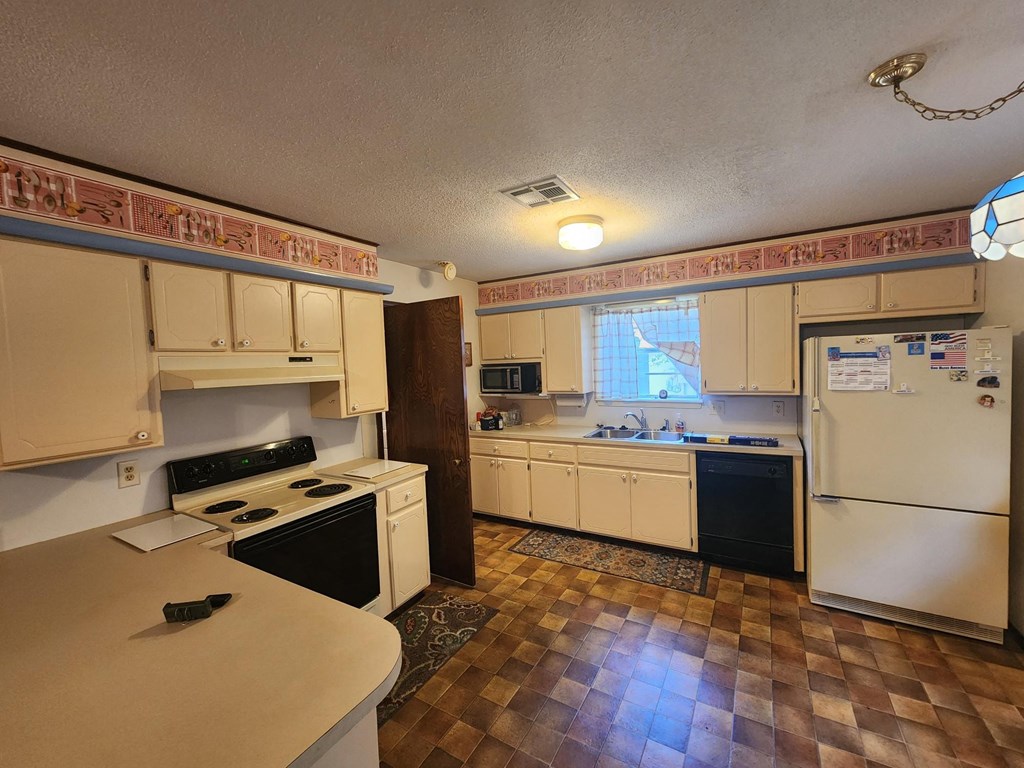 a kitchen with a stove refrigerator and a sink