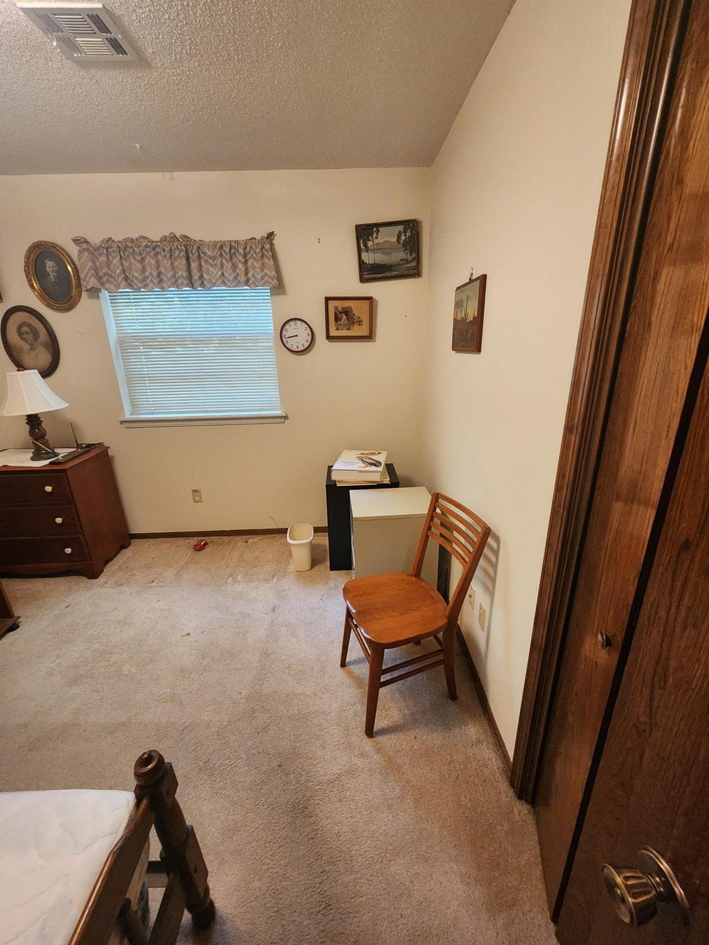 a bedroom with a bed and a chair in it