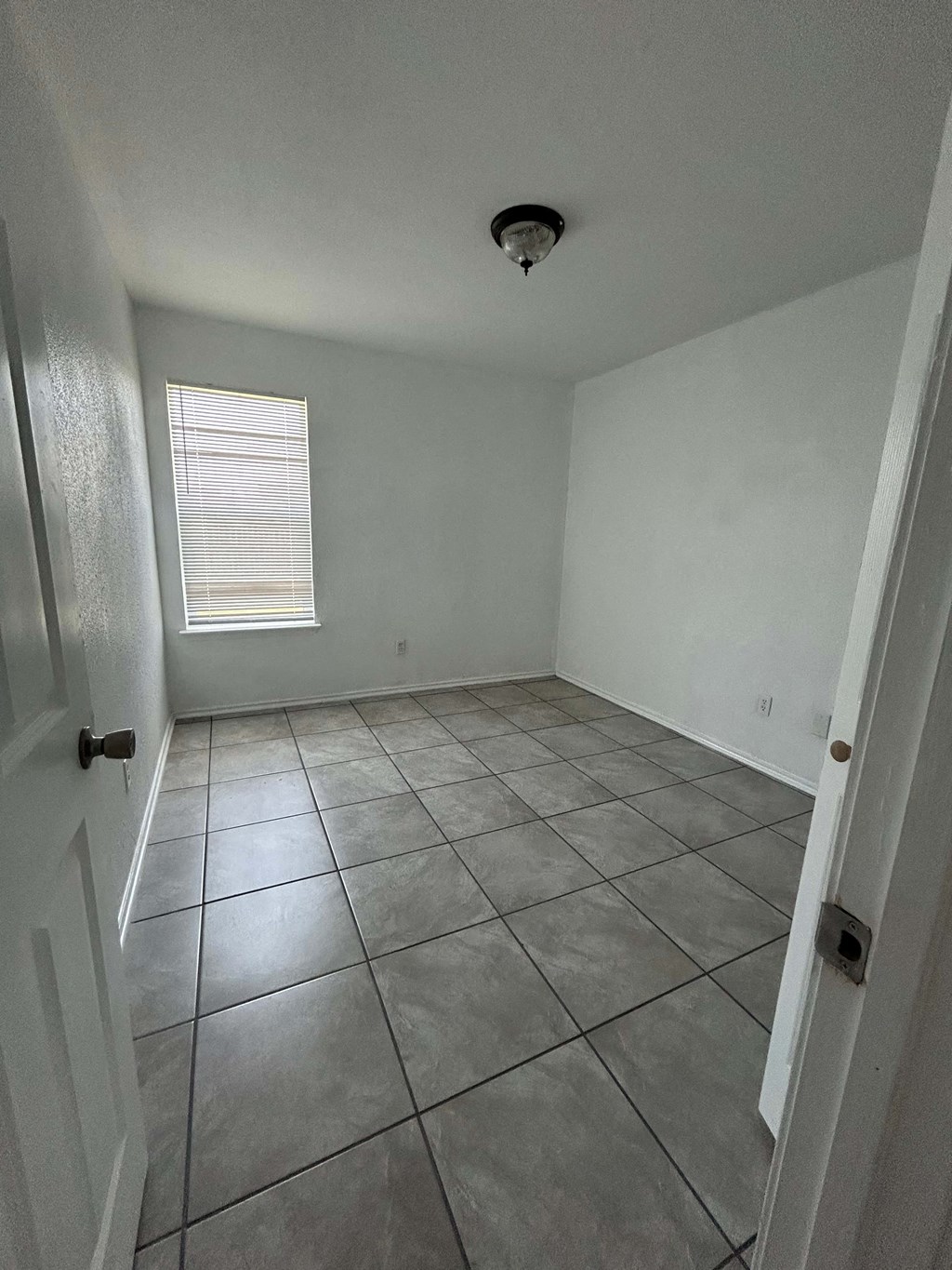 a room with a tiled floor and a window