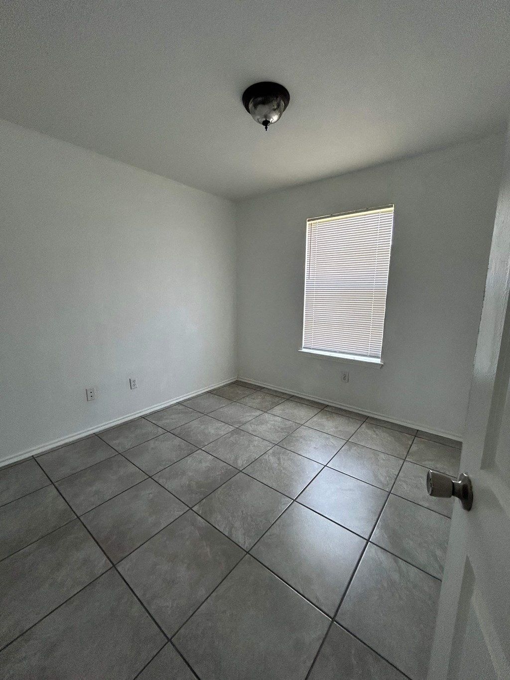 an empty room with tile floors and a window