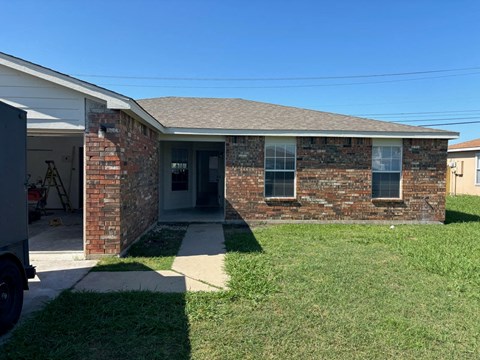 a brick house with a lawn and a truck in front