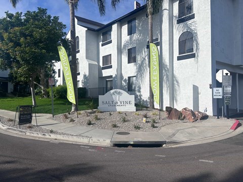 Salt's Vine is a modern building with a white facade and green banners.