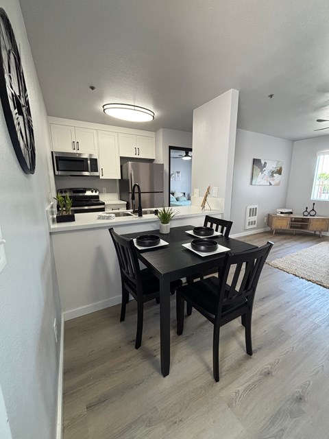 A modern kitchen with a dining table set for two.