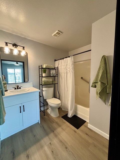 A bathroom with a toilet, sink, and shower.