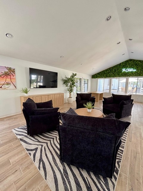 A living room with a zebra print rug and a flat screen TV mounted on the wall.