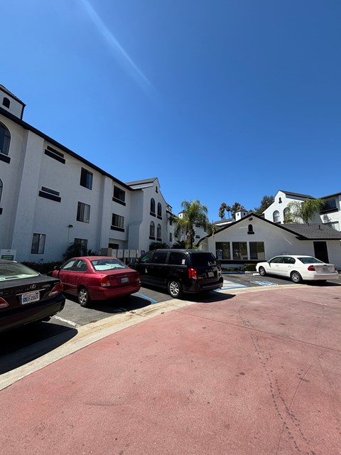 A parking lot with cars and apartment buildings in the background.