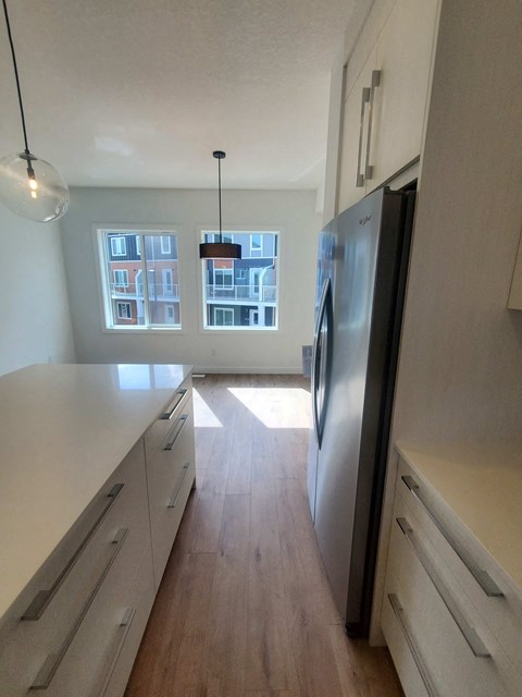 a kitchen with white cabinets and a stainless steel refrigerator