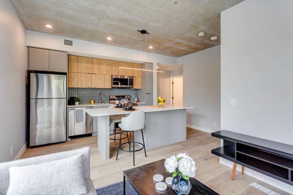 a living room with a kitchen and a table with chairs