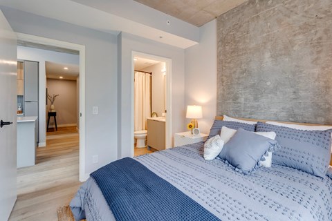 a bedroom with a blue and white bed and a bathroom