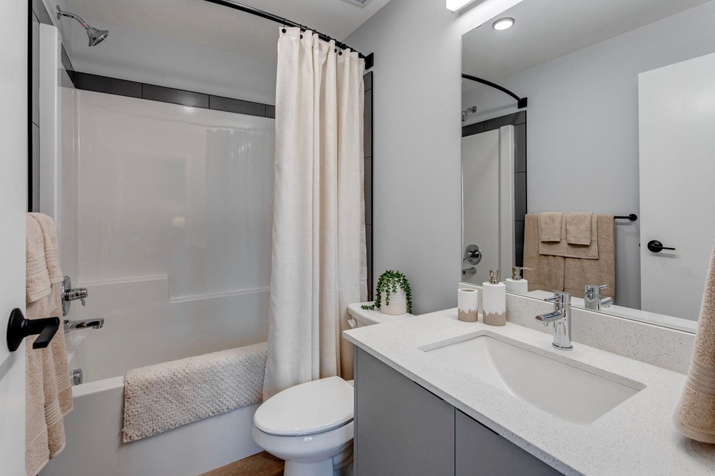 a bathroom with a shower and a sink and a toilet