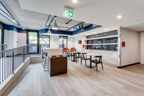 a dining area with tables and chairs and a counter in the middle of a room