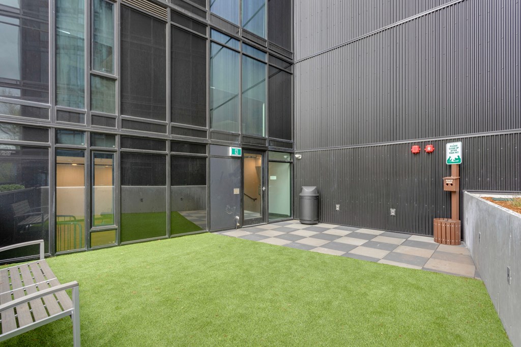 the courtyard of a building with grass and a bench