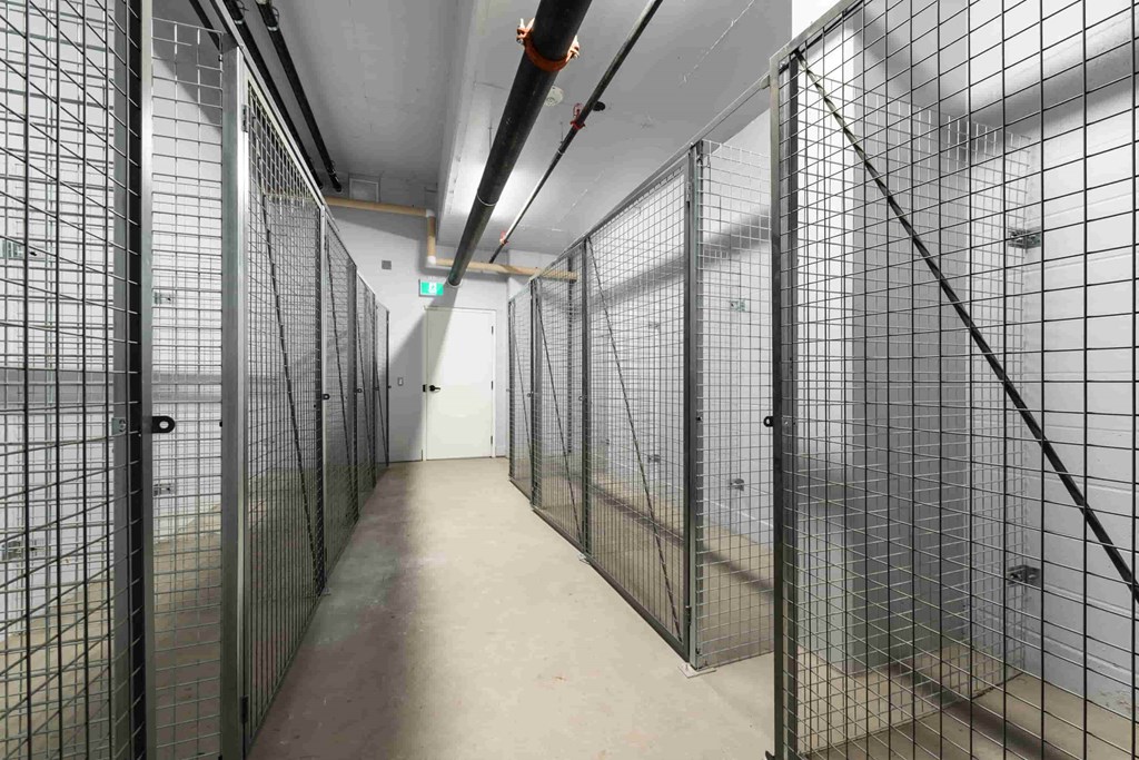 a row of prison cells in a long hallway with metal bars
