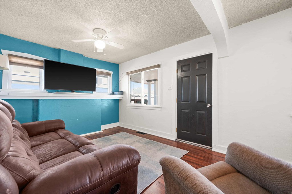 a living room with a leather couch and a tv