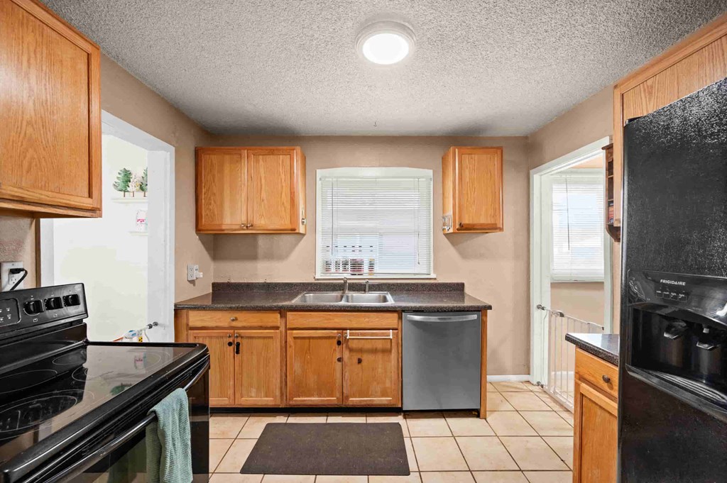 an empty kitchen with wooden cabinets and a sink