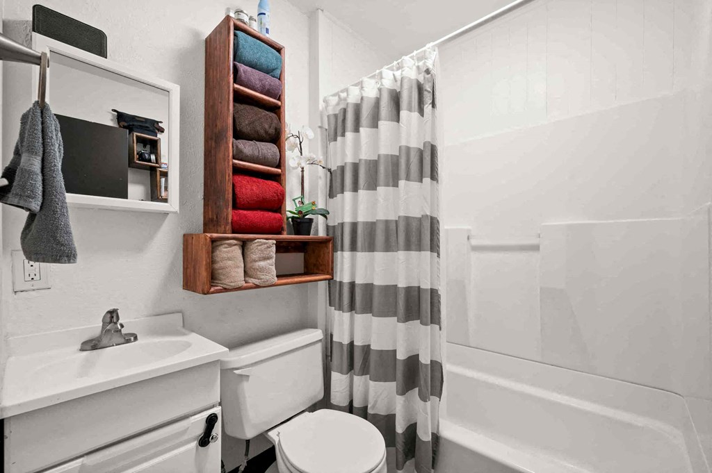 a bathroom with a shower curtain and a sink and a toilet