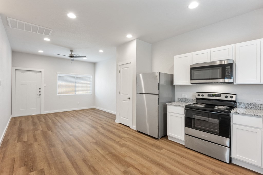 a renovated kitchen with white cabinets and stainless steel appliances