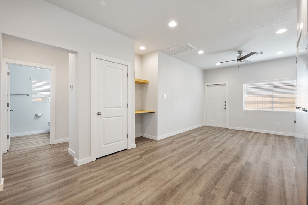 an empty living room with a closet and a door to a bathroom