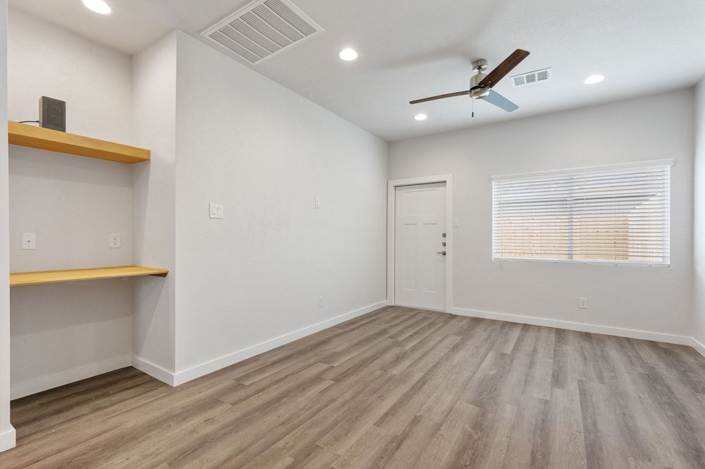 a living room with white walls and a ceiling fan