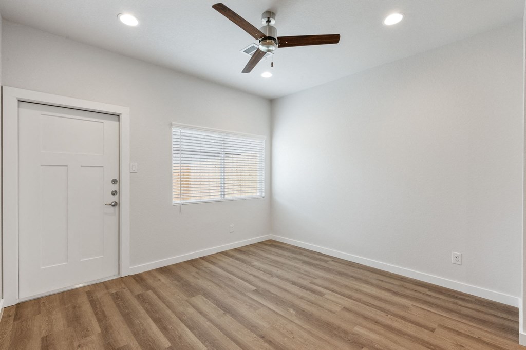 an empty room with a ceiling fan and a door