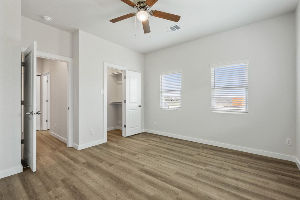 the living room of an empty house with a ceiling fan