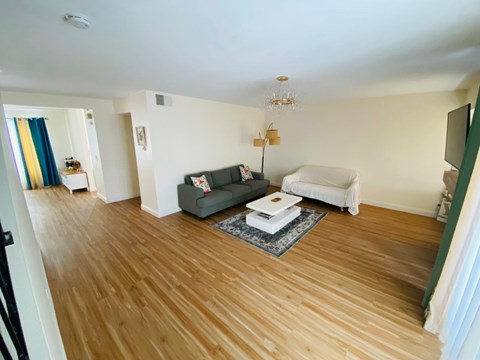A living room with a grey couch and a white sofa.