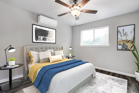 A bedroom with a bed, a ceiling fan, and a window.