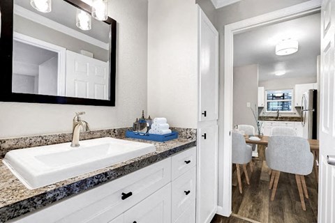 a white bathroom with a sink and a mirror