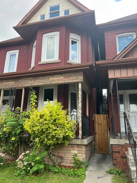a red brick house with a front porch and a wooden door