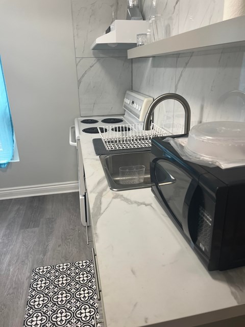 A black microwave oven is on a white countertop.