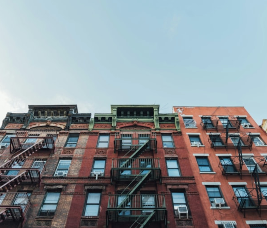 A red brick building with black fire escapes.