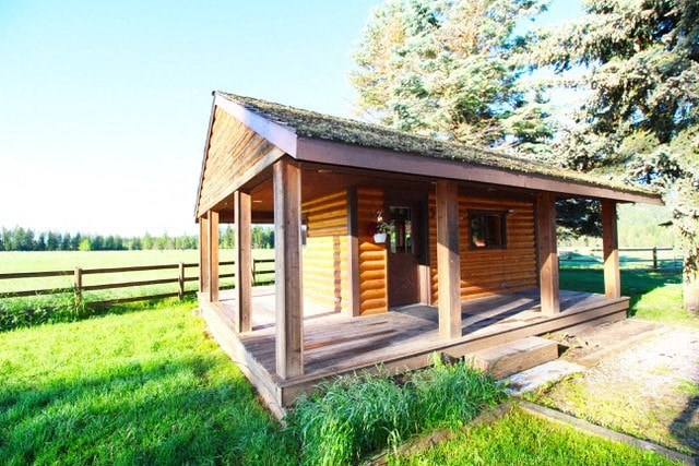 a small wooden cabin in the middle of a field