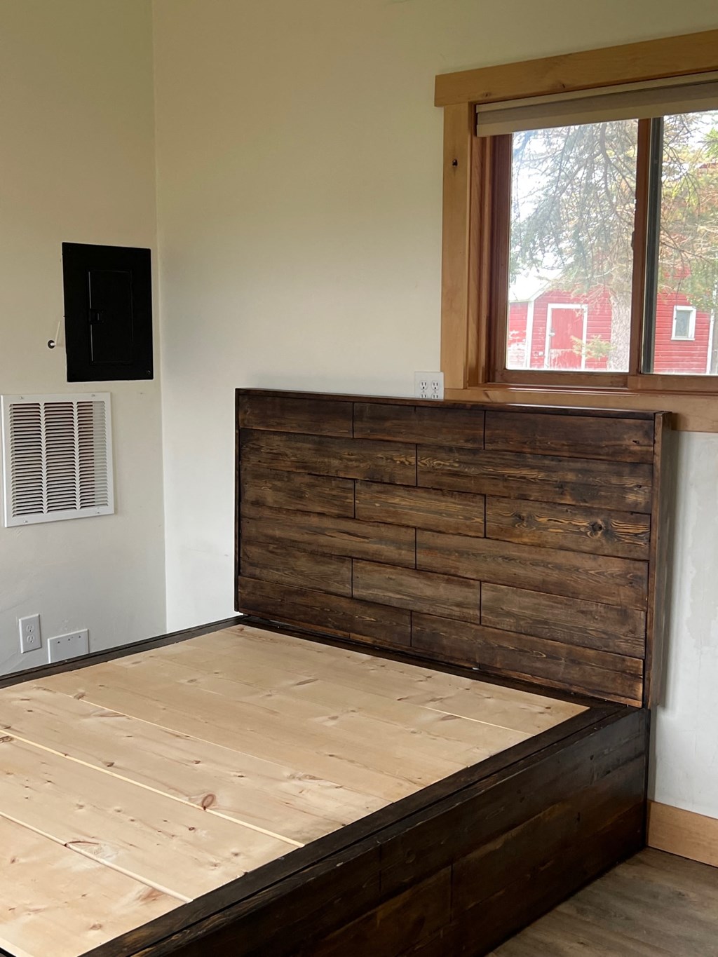 a bed in a room with a wooden headboard and a window